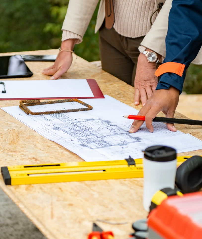Engineers reviewing construction plans outdoors
